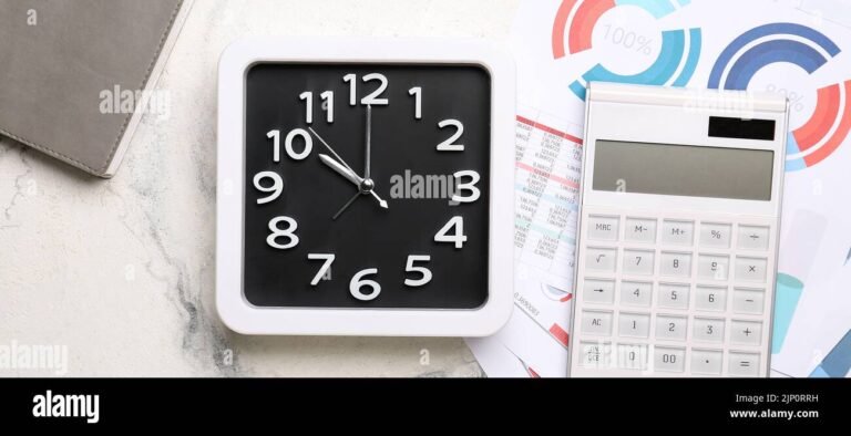 calculadora documentos e relogio sobre mesa