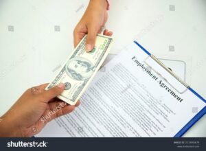 contrato de trabalho sendo assinado e dinheiro