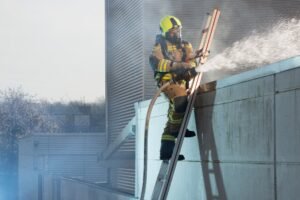 escada externa apoiada com cinto de seguranca