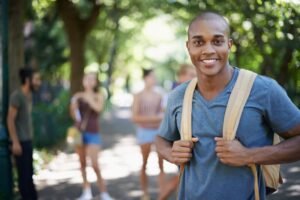 jovem feliz estudando com mochila na escola