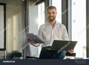 jovem sorrindo com laptop e documentos