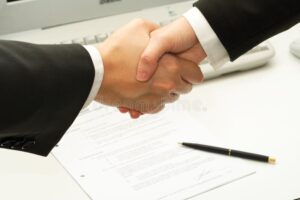 maos apertando contrato assinado formalmente