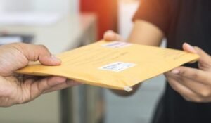 maos entregando envelope de rescisao salarial