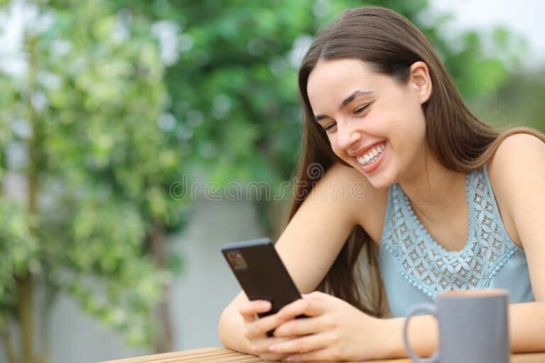mulher feliz checando celular em casa
