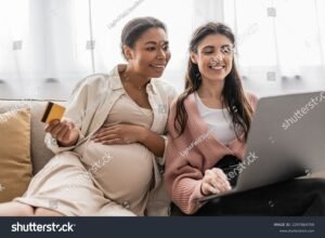 mulher gravida feliz segurando carteira de trabalho