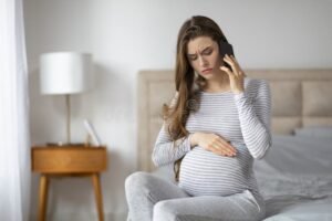 mulher gravida segurando barriga preocupada