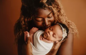 mulher gravida segurando bebe e carteira trabalhista