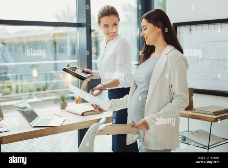 Gestante Reintegrada Recebe Salários Durante Tempo de Afastamento 2 mulher gravida sorrindo com documentos trabalhistas