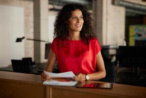 mulher pensativa segurando documentos trabalhistas