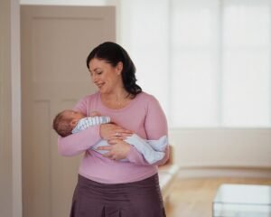 mulher sorrindo com bebe nos bracos