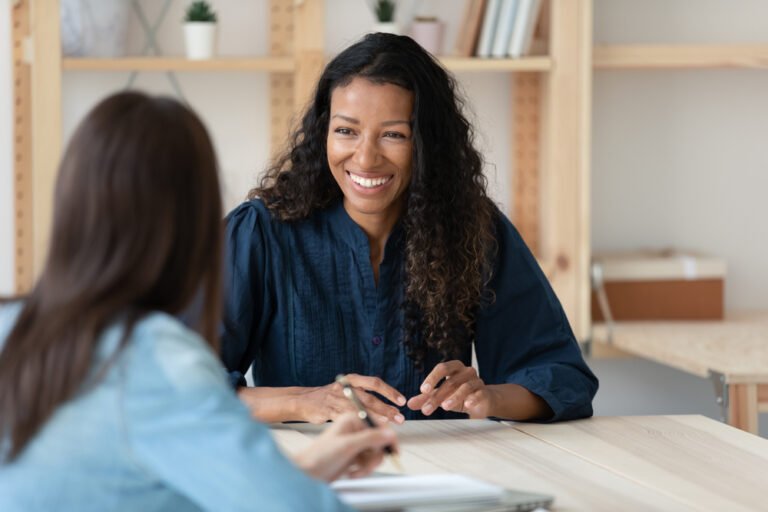 mulher sorrindo confidenciando segredo no escritorio