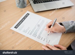 pessoa assinando documento de demissao formal