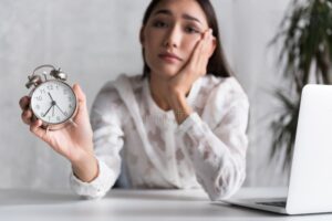 pessoa cansada olhando para relogio no trabalho