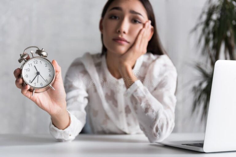 pessoa cansada olhando para relogio no trabalho