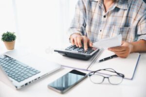 pessoa organizando financas com calculadora