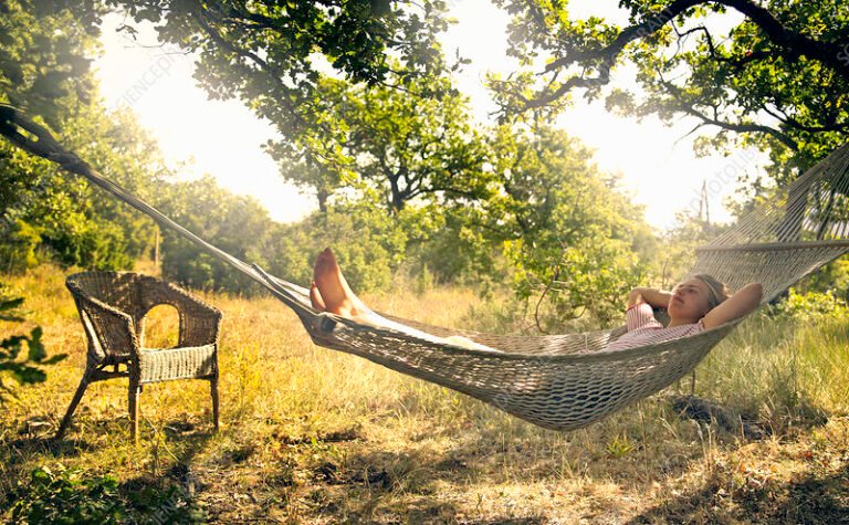 pessoa relaxando em rede ao ar livre