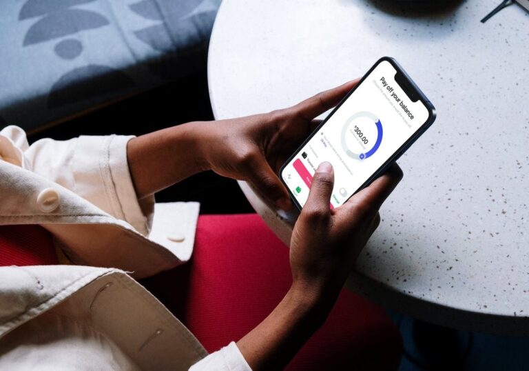 pessoa verificando saldo em smartphone moderno