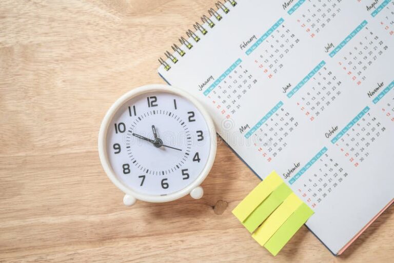 relogio e calendario sobre mesa de trabalho