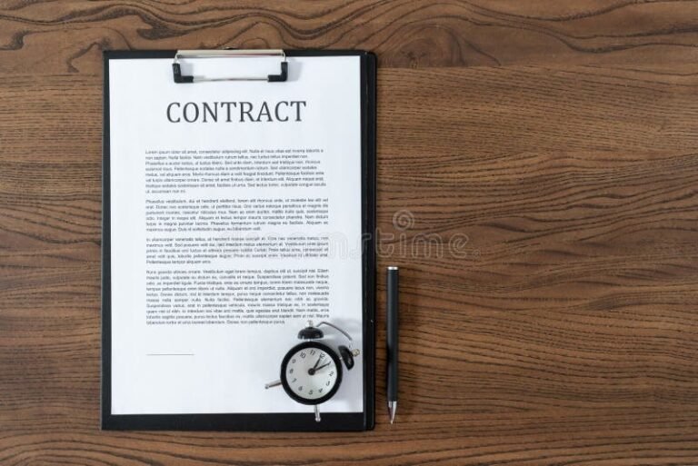 relogio e contrato sobre mesa de madeira