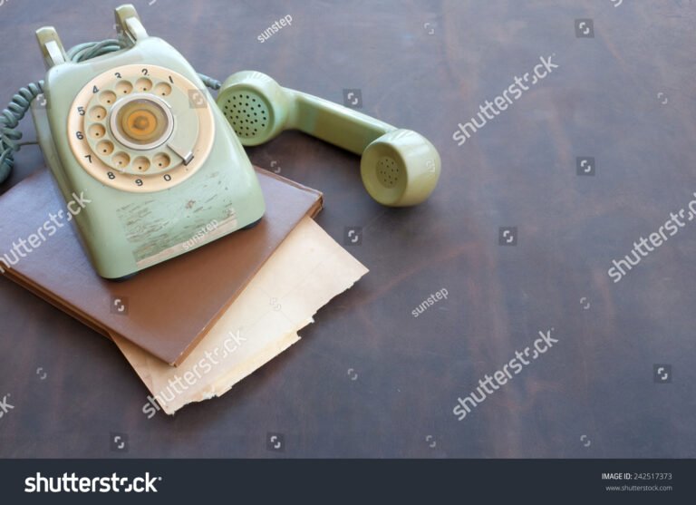 telefone vintage sobre mesa com papeis